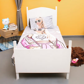 Pink fashion-doll-print children's bedsheet and matching pillowcase on a single bed.