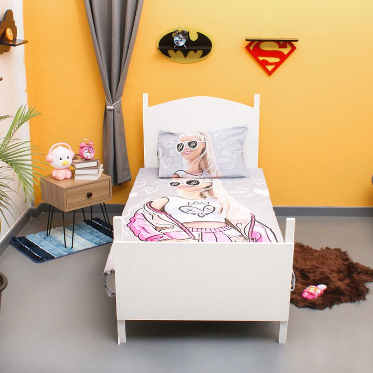 Pink fashion-doll-print children's bedsheet and matching pillowcase on a single bed.