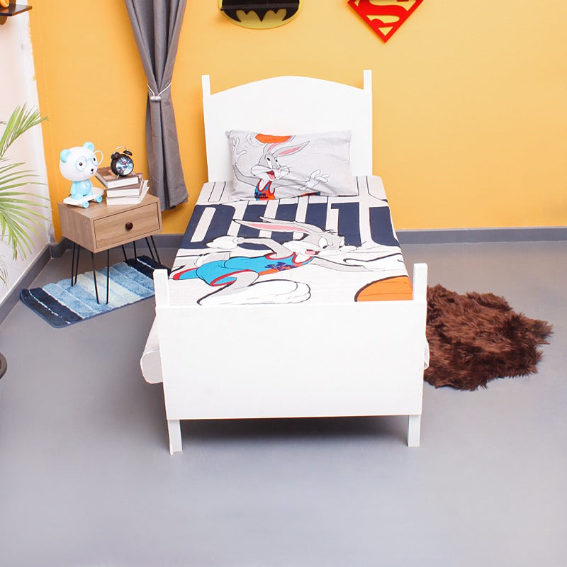 Front view of a single bed dressed in a cartoon rabbit-print bedsheet.
