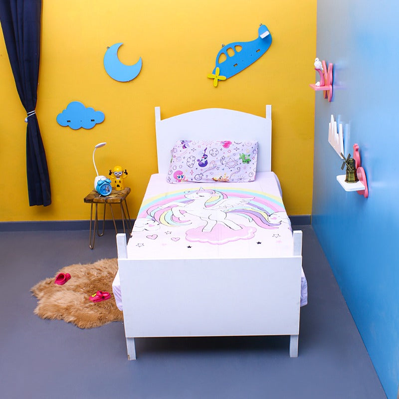 Pastel unicorn-print children's bedsheet and matching pillowcase on a single bed.