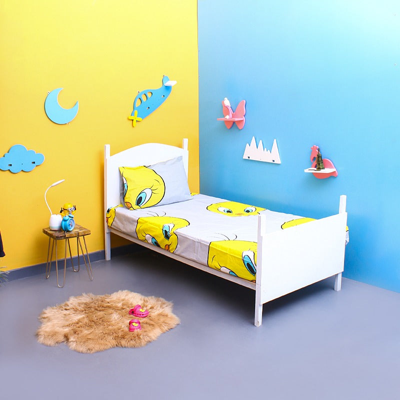 Yellow cartoon-bird-print bedsheet and pillowcase on a single bed.