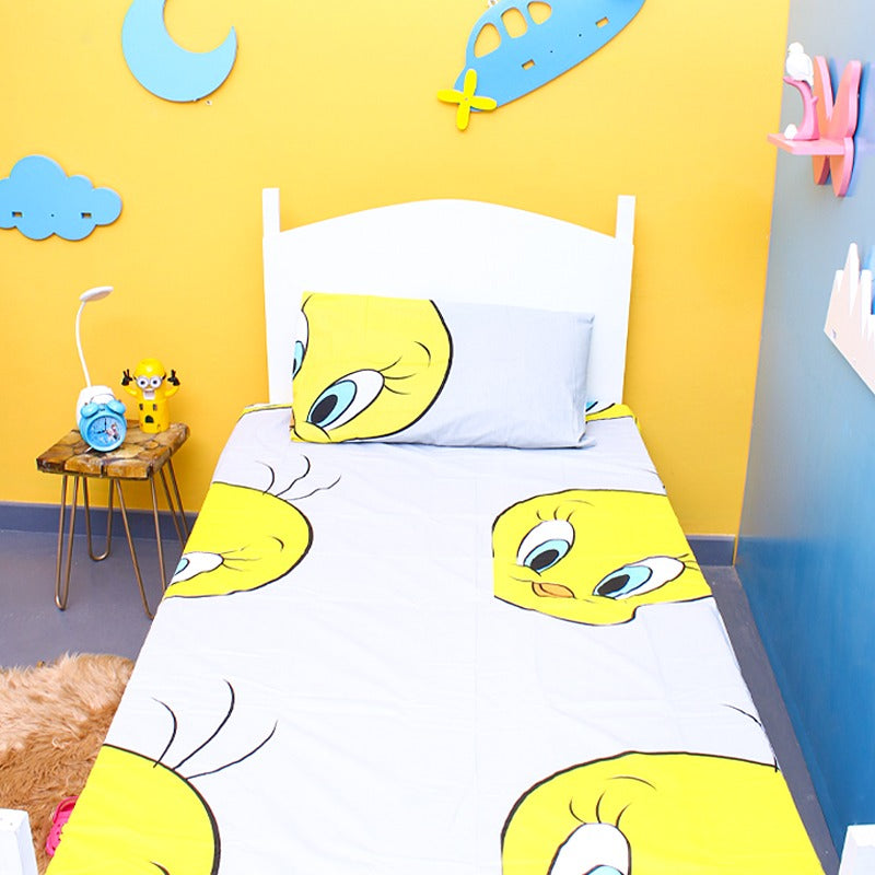 White children's bedsheet with a large yellow cartoon-bird print.