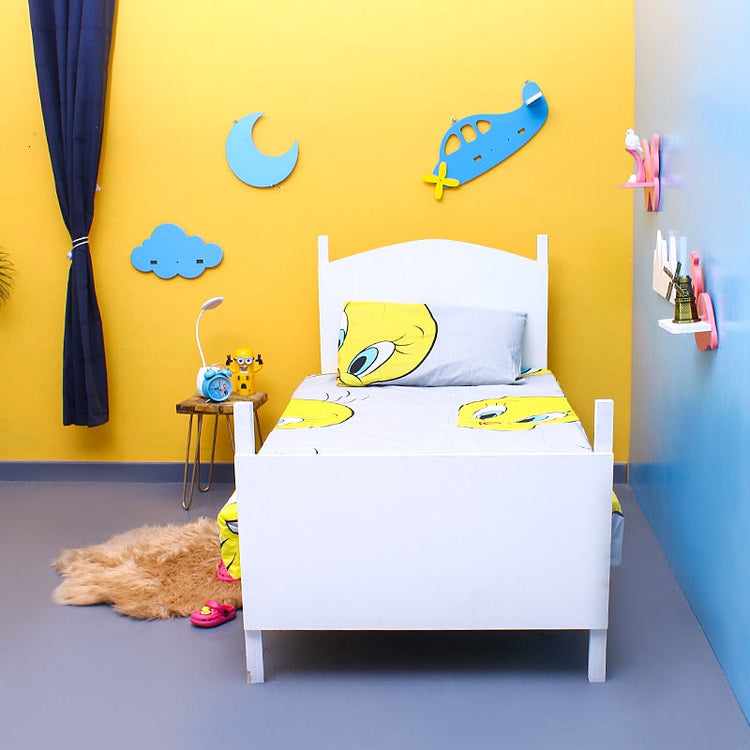 Yellow cartoon-bird-print bedsheet and pillowcase on a single bed.