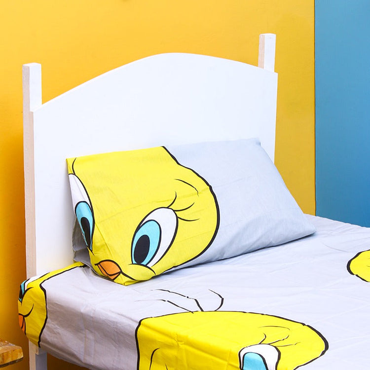 Close-up of a yellow cartoon-bird pillowcase and matching white bedsheet.