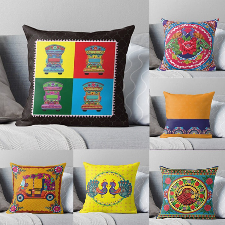 Six colourful truck art cushion covers displayed on a grey sofa.