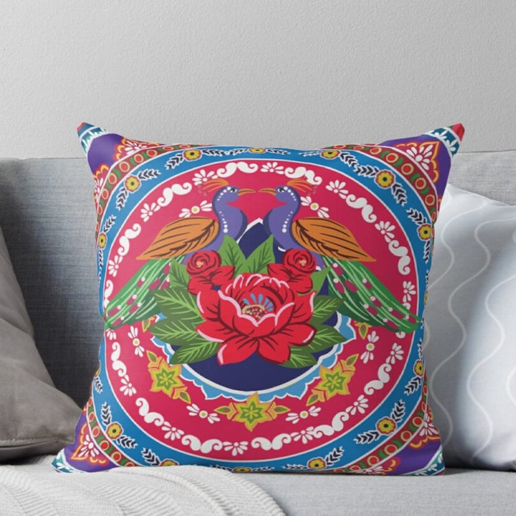Cushion cover with colourful birds and flowers inside an ornate circular border.