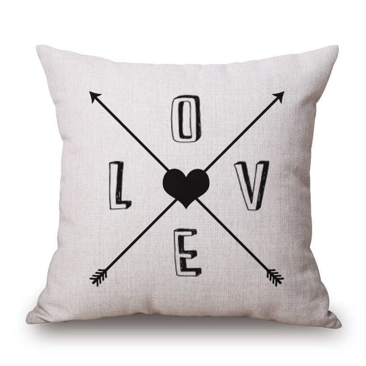 Cream cushion cover with crossed arrows, a heart and LOVE lettering.