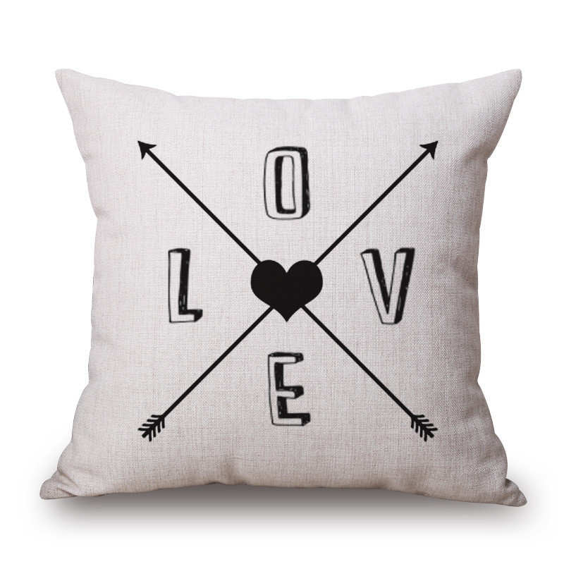 Cream cushion cover with crossed arrows, a heart and LOVE lettering.