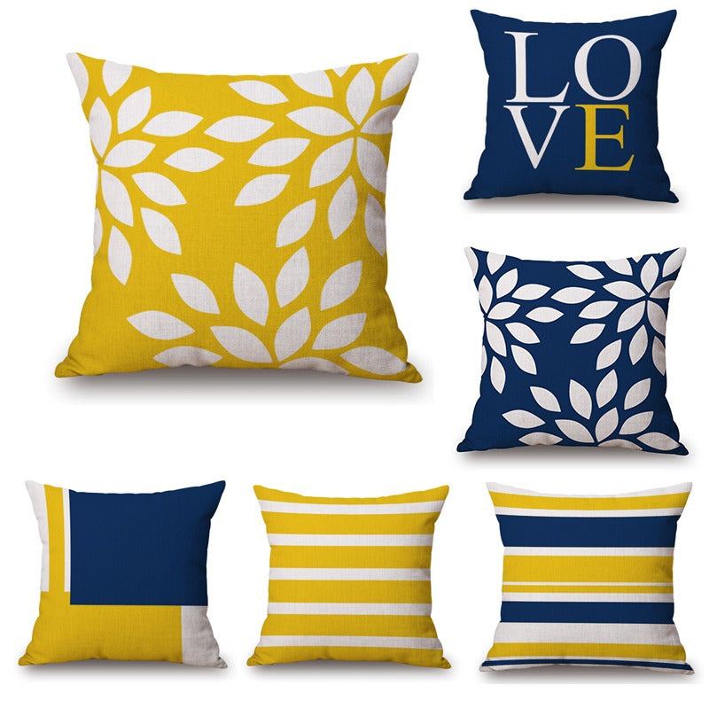 Six navy, yellow and white cushion covers with stripes, leaves, colour blocks and LOVE lettering.