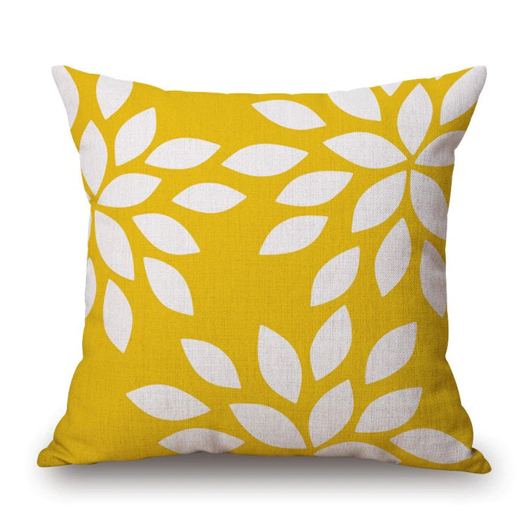 Yellow cushion cover with white leaf shapes.