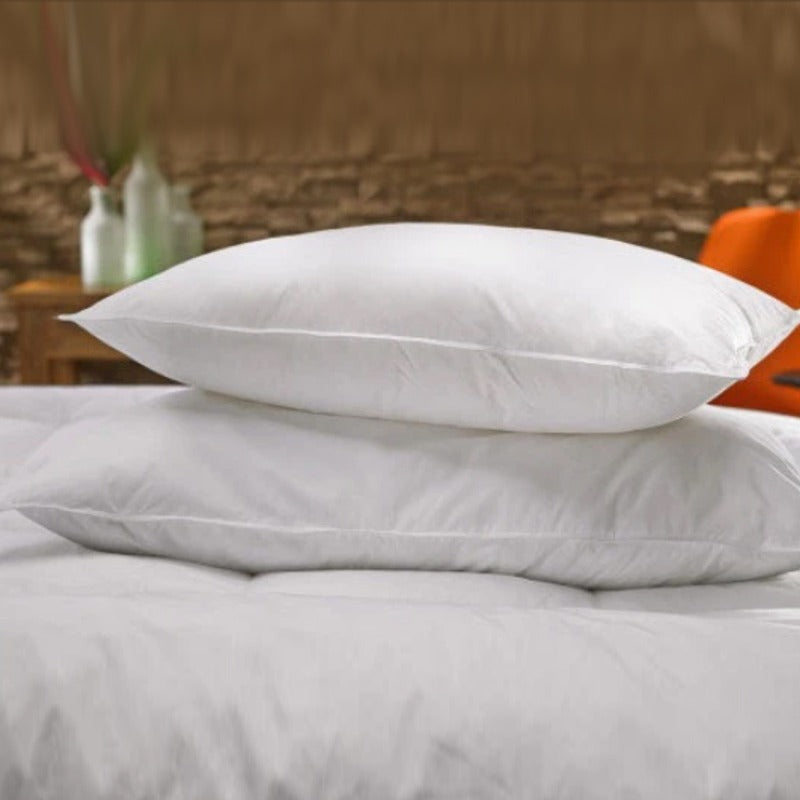 Two white fibre-filled pillows on white bedding.