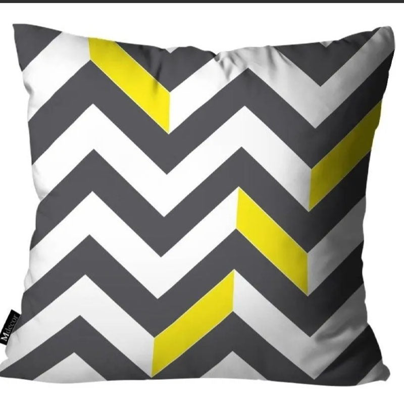Grey cushion cover with white zigzag stripes and yellow accents.