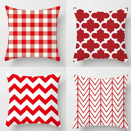 Four red and white cushion covers with check, lattice and zigzag patterns.