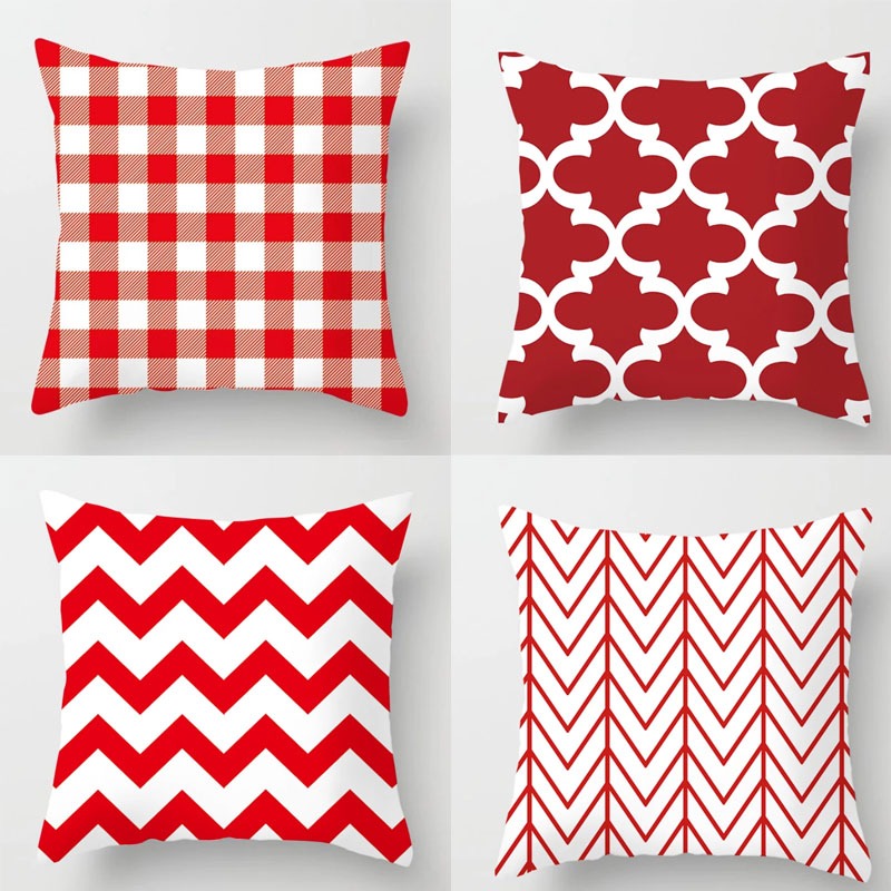 Four red and white cushion covers with check, lattice and zigzag patterns.