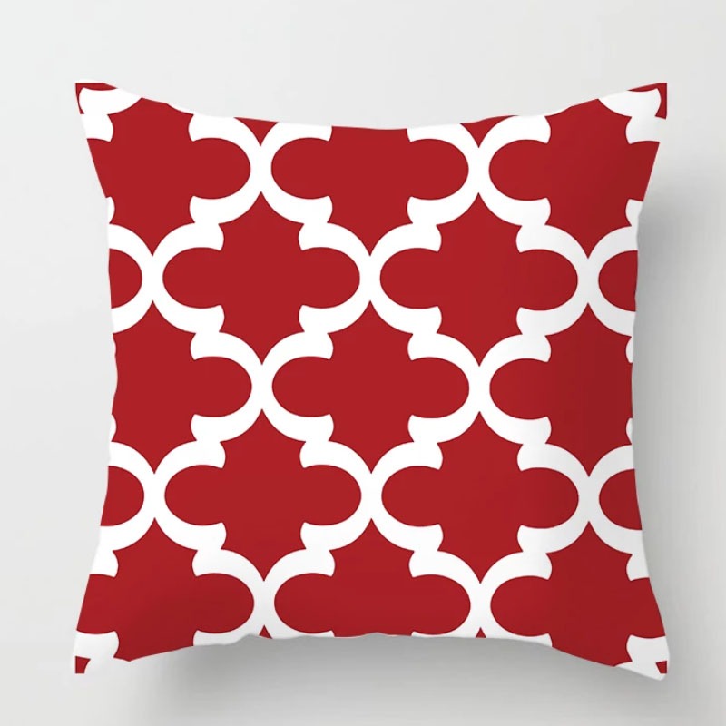 Red cushion cover with a white interlocking quatrefoil pattern.
