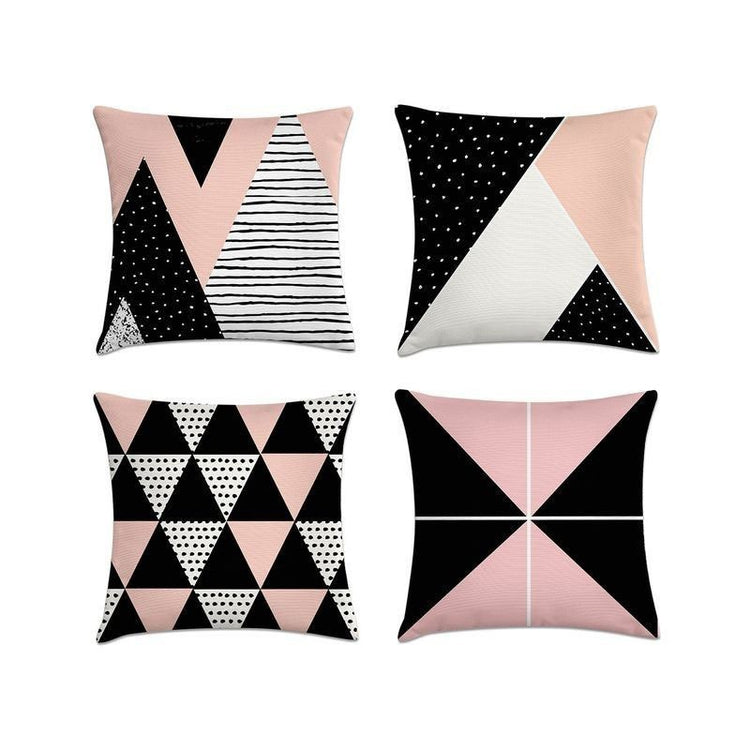 Four pink, black and white cushion covers with assorted triangle patterns.
