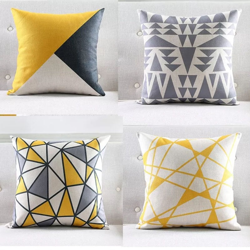 Four yellow, grey and white geometric cushion covers.