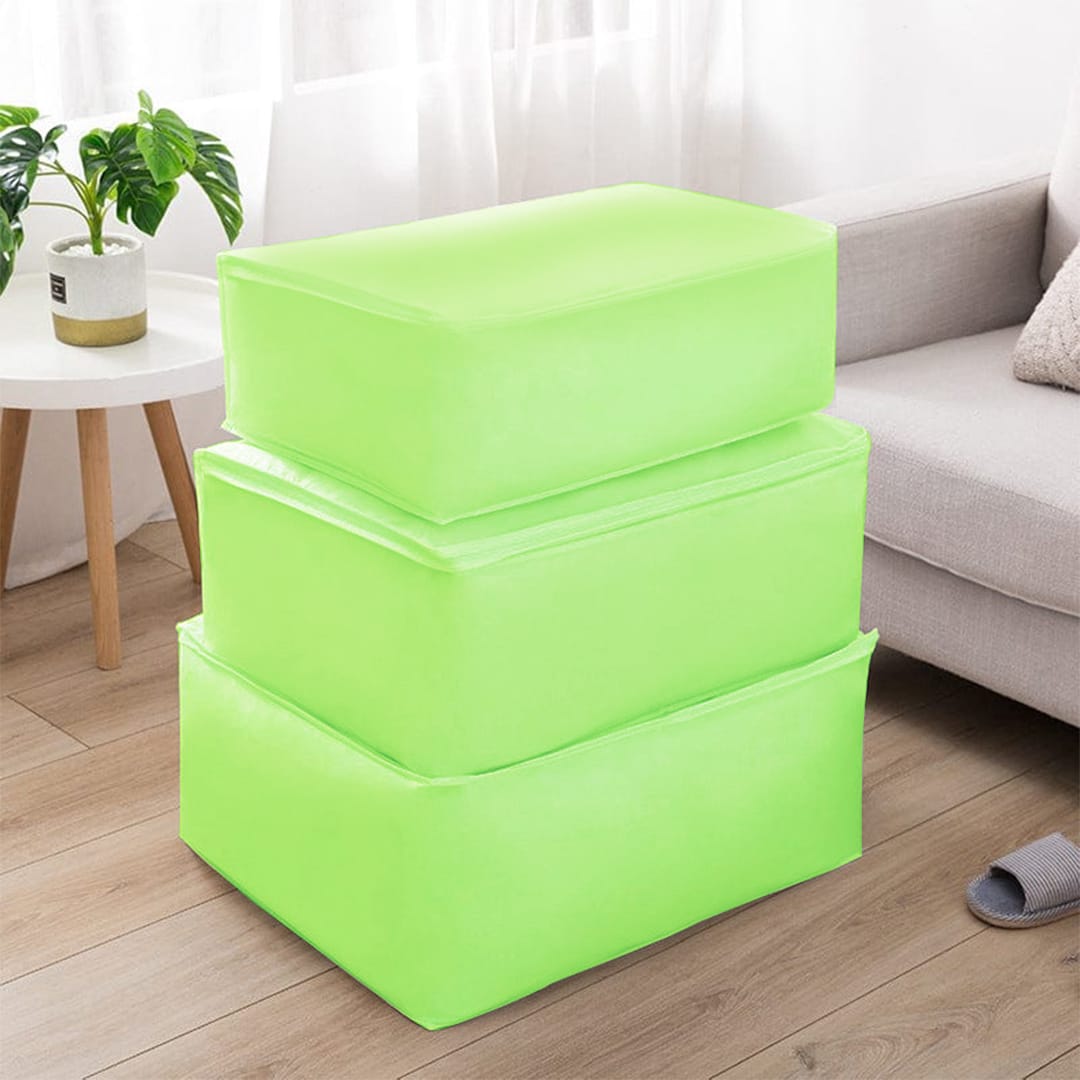 Three lime green fabric storage cubes stacked beside a sofa.