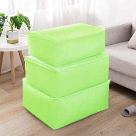 Three lime green fabric storage cubes stacked beside a sofa.
