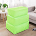 Three lime green fabric storage cubes stacked beside a sofa.