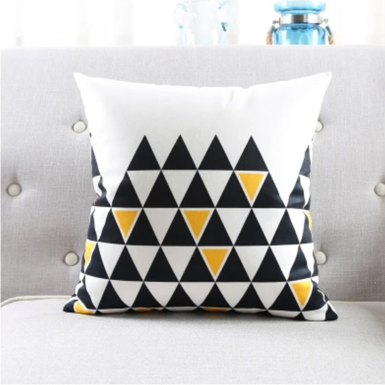 White cushion cover with rows of black triangles and small yellow accents.