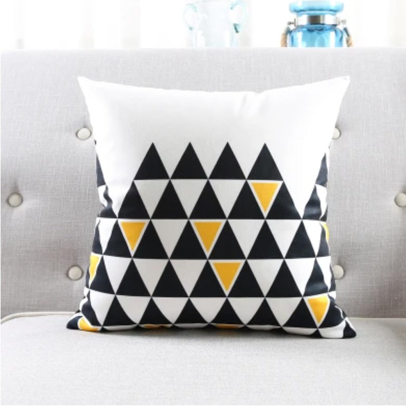 White cushion cover with rows of black triangles and small yellow accents.
