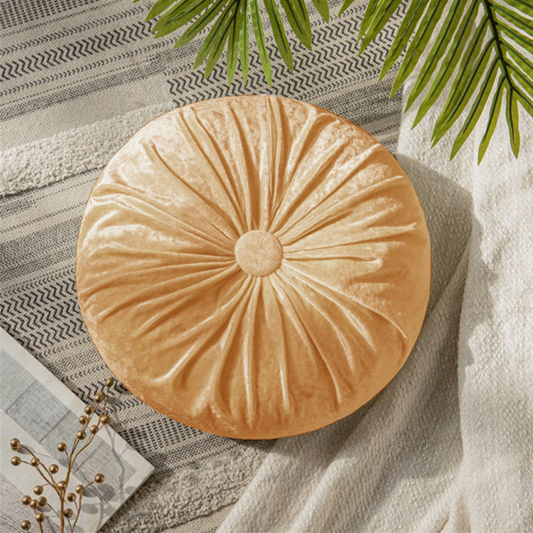 Round peach cushion with radial pleats and a covered centre button.