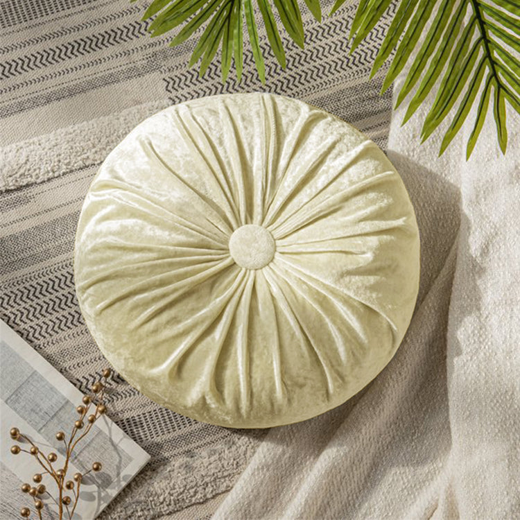 Round cream cushion with radial pleats and a covered centre button.