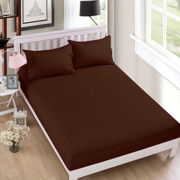 Chocolate brown fitted sheet displayed on a bed with matching pillowcases.