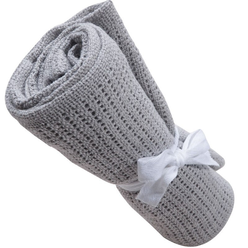 Rolled grey cellular blanket tied with a white ribbon.