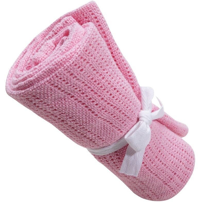 Rolled pink cellular blanket tied with a white ribbon.