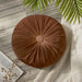Round brown cushion with radial pleats and a covered centre button.