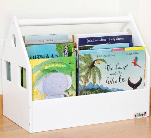 Close-up of a white house-shaped book bin filled with illustrated children's books.