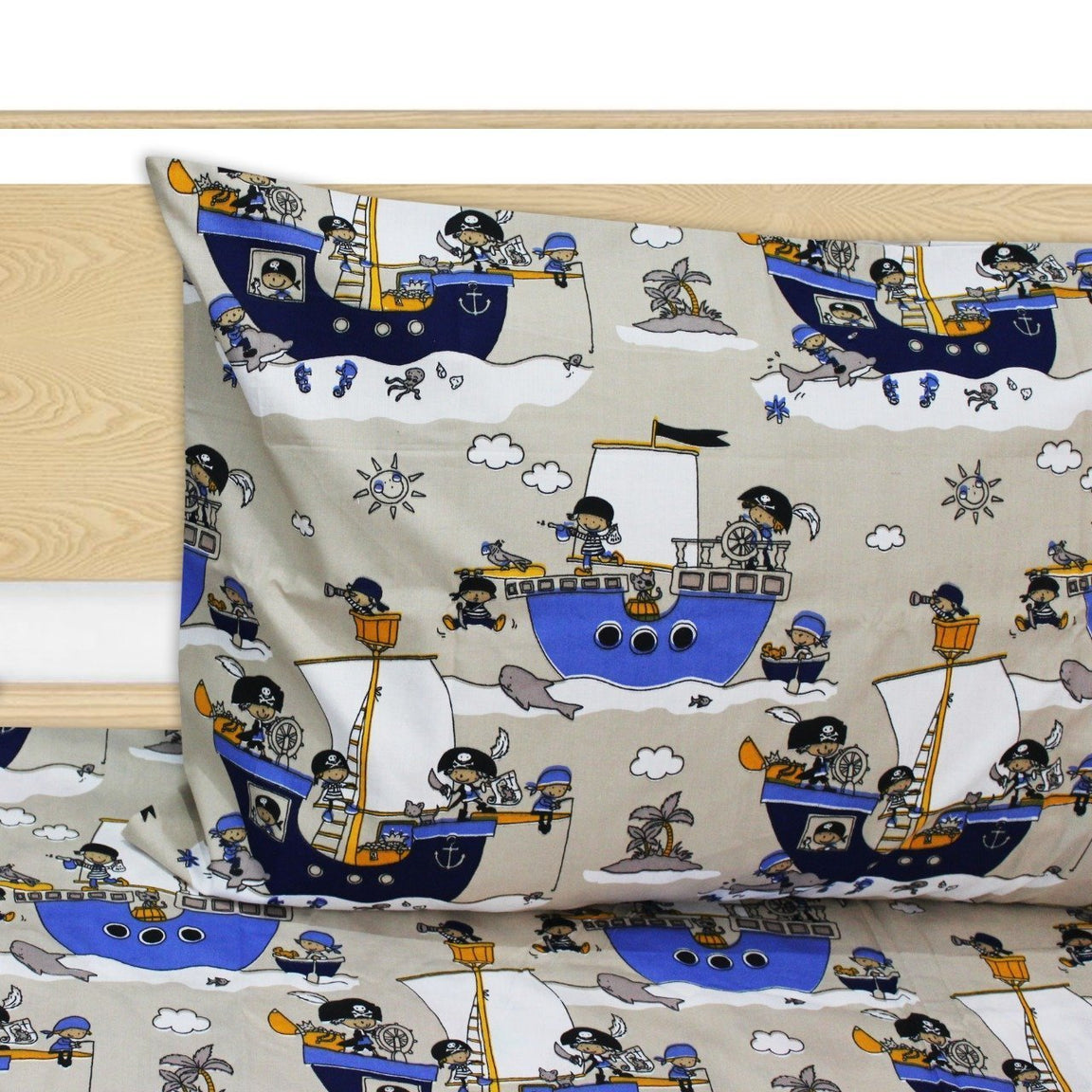 Close-up of a grey pillowcase and bedsheet with blue cartoon pirate ships.