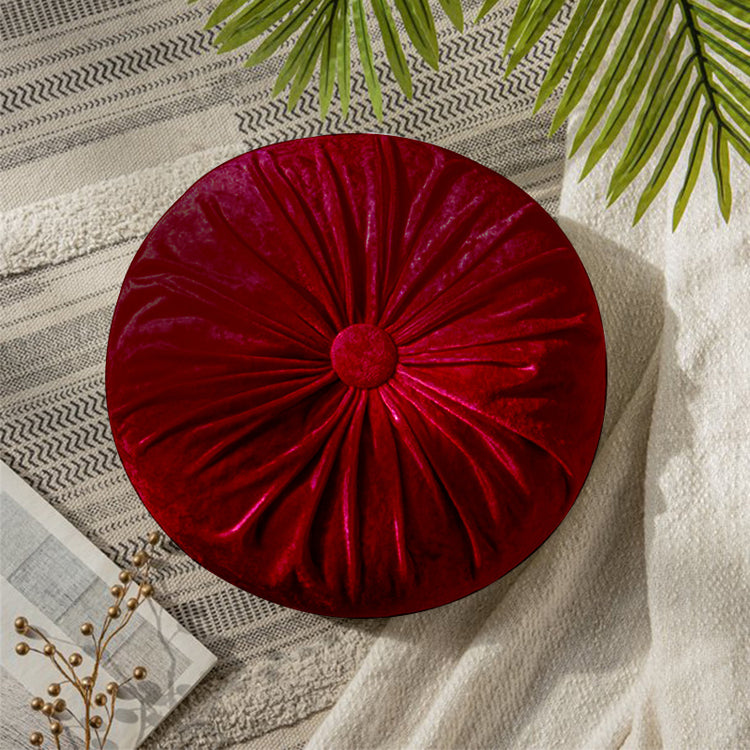 Round burgundy cushion with radial pleats and a covered centre button.