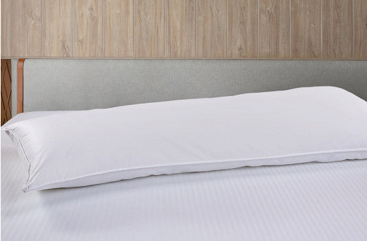Long white body pillow displayed horizontally on a bed.