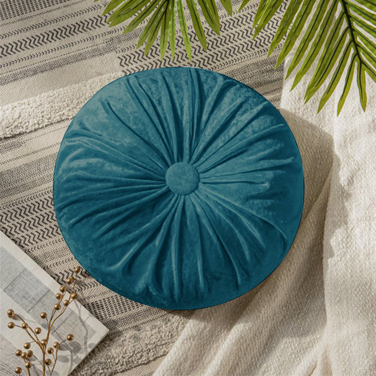 Round teal cushion with radial pleats and a covered centre button.